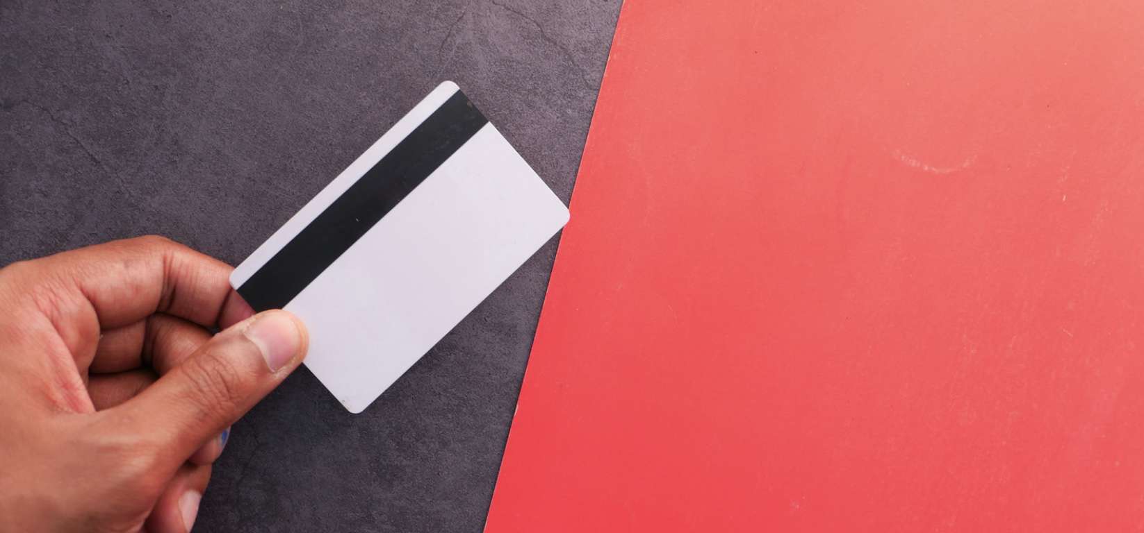 Hand-Holding-Credit-Card-on-Color-Background